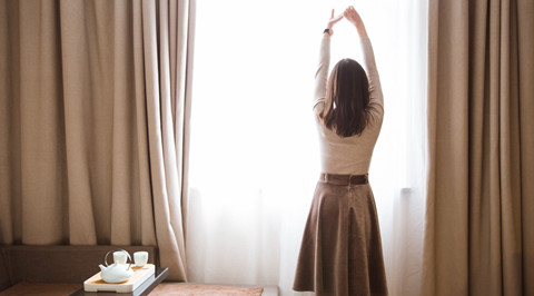 The picture shows a woman standing at the window