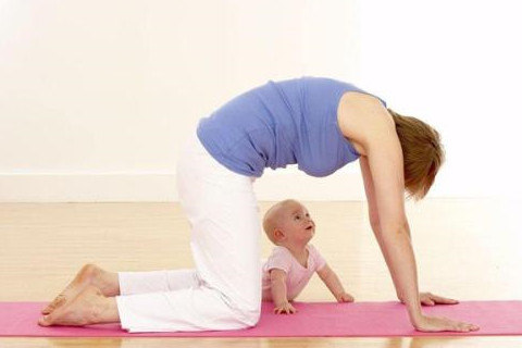 The picture shows a mom doing yoga with her baby